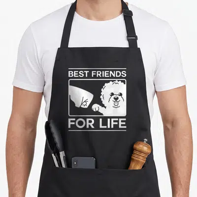 Friend christmas dog apron - White line art of a dog and hand inside a frame with Best Friends For Life text — shown on a black cotton canvas apron against a white background