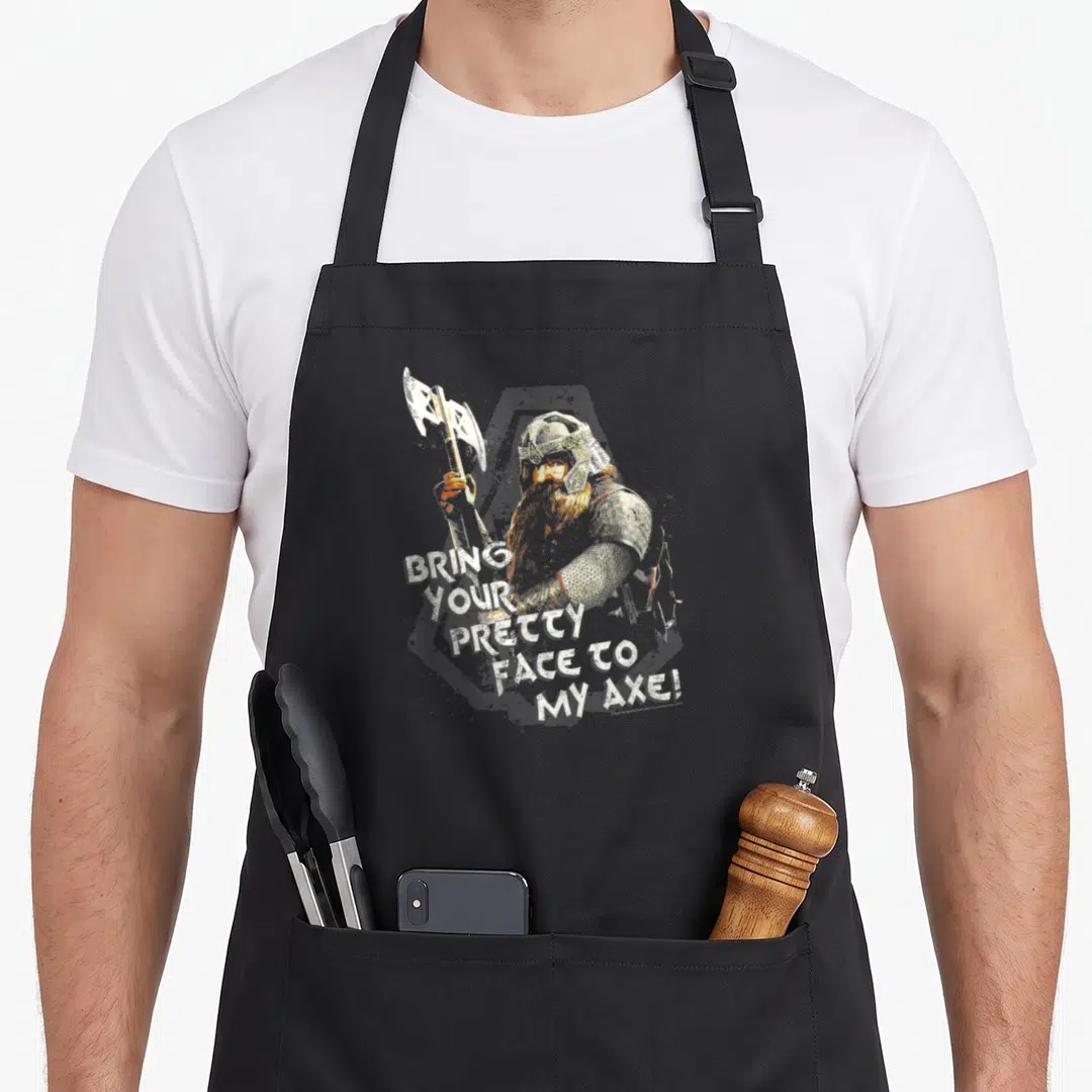 Gimli ring apron - Distressed viking holding axe with text bring your pretty face to my axe — shown on a black cotton canvas apron against a white background
