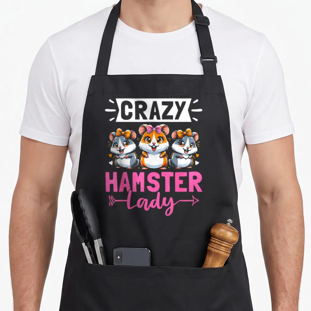 Hamster rodent pet apron - CRAZY HAMSTER Lady text with three cartoon hamsters in pink orange grey and white — shown on a black cotton canvas apron against a white background