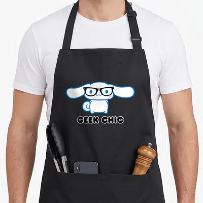 Cinnamoroll geek apron - White cartoon dog with black glasses and GEEK CHIC text on black background — shown on a black cotton canvas apron against a white background