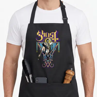 Blessed ghost apron - GHOST text above skeleton couple in purple yellow blue geometric frame with candles — shown on a black cotton canvas apron against a white background