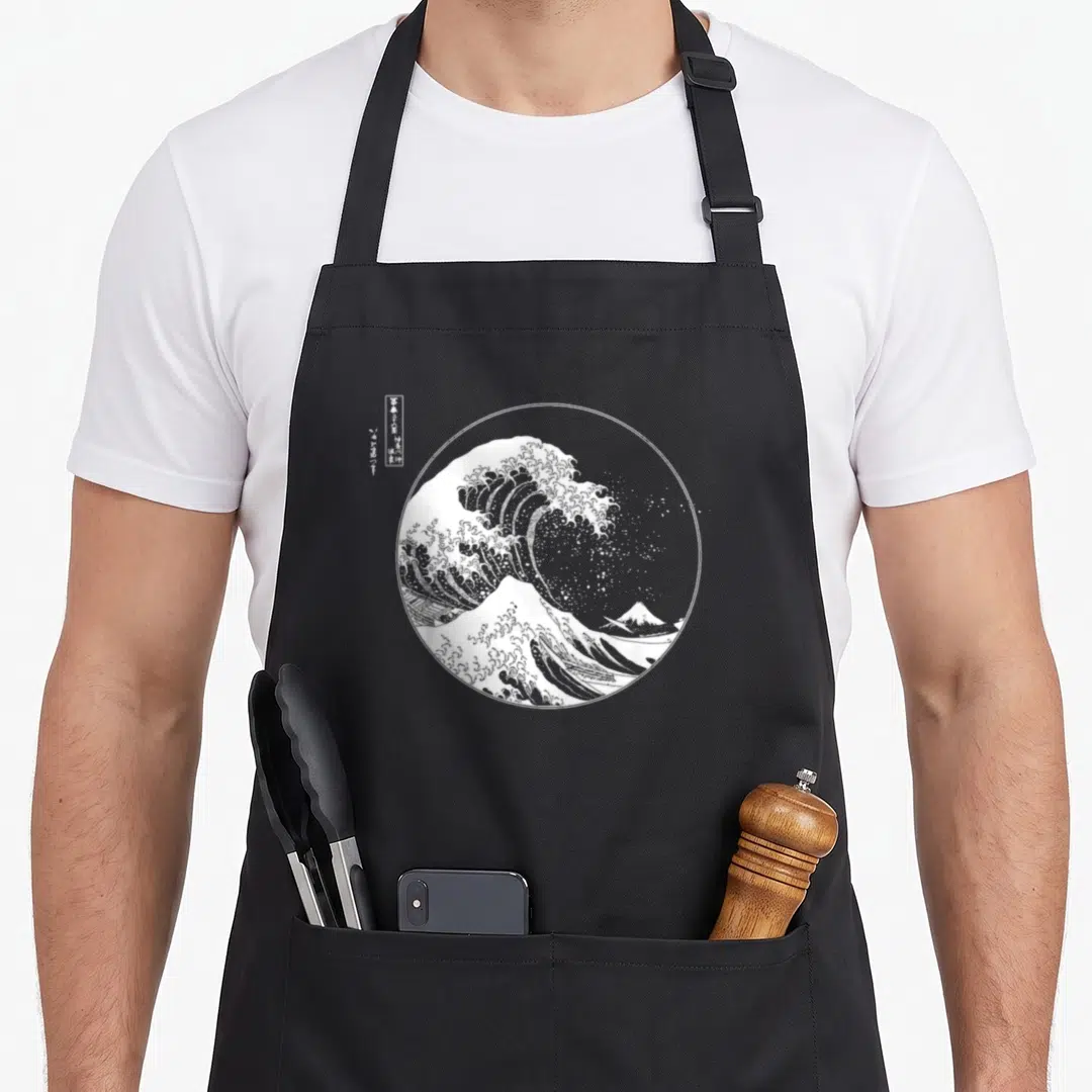Hokusai japanese wave apron - White line-art wave and mountain in circle with vertical Japanese text — shown on a black cotton canvas apron against a white background