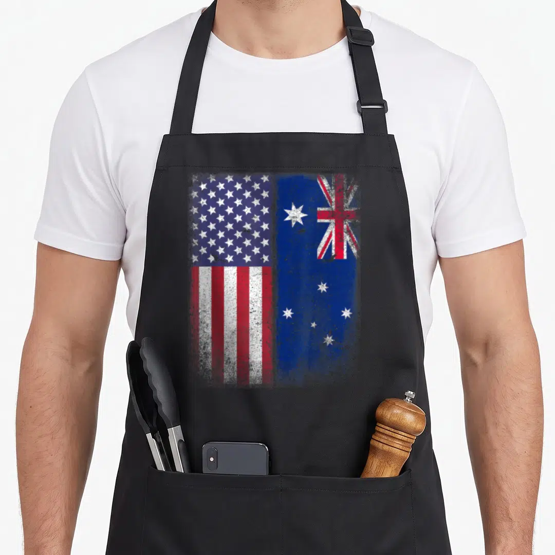 Flag australian apron - Distressed USA and Australian flags side by side in red white blue — shown on a black cotton canvas apron against a white background
