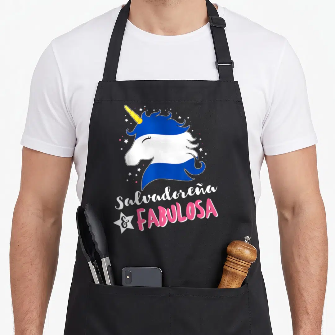 Unicornio salvadoran apron - Cartoon unicorn head in blue white pink with Salvadoreña and Fabulosa text and white star — shown on a black cotton canvas apron against a white background