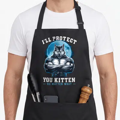 Protect alpha apron - Cartoon muscular wolf crossed arms blue moon I'll Protect You Kitten text — shown on a black cotton canvas apron against a white background