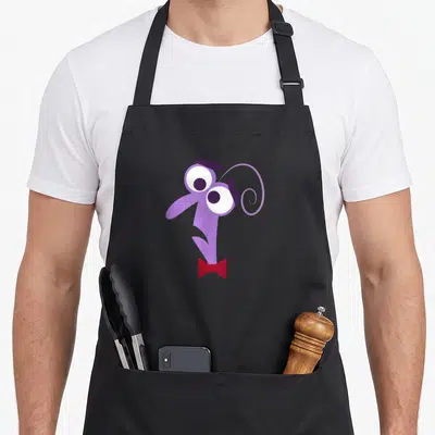 Funny fear apron - Purple cartoon monster head with white eyes and red bow tie — shown on a black cotton canvas apron against a white background