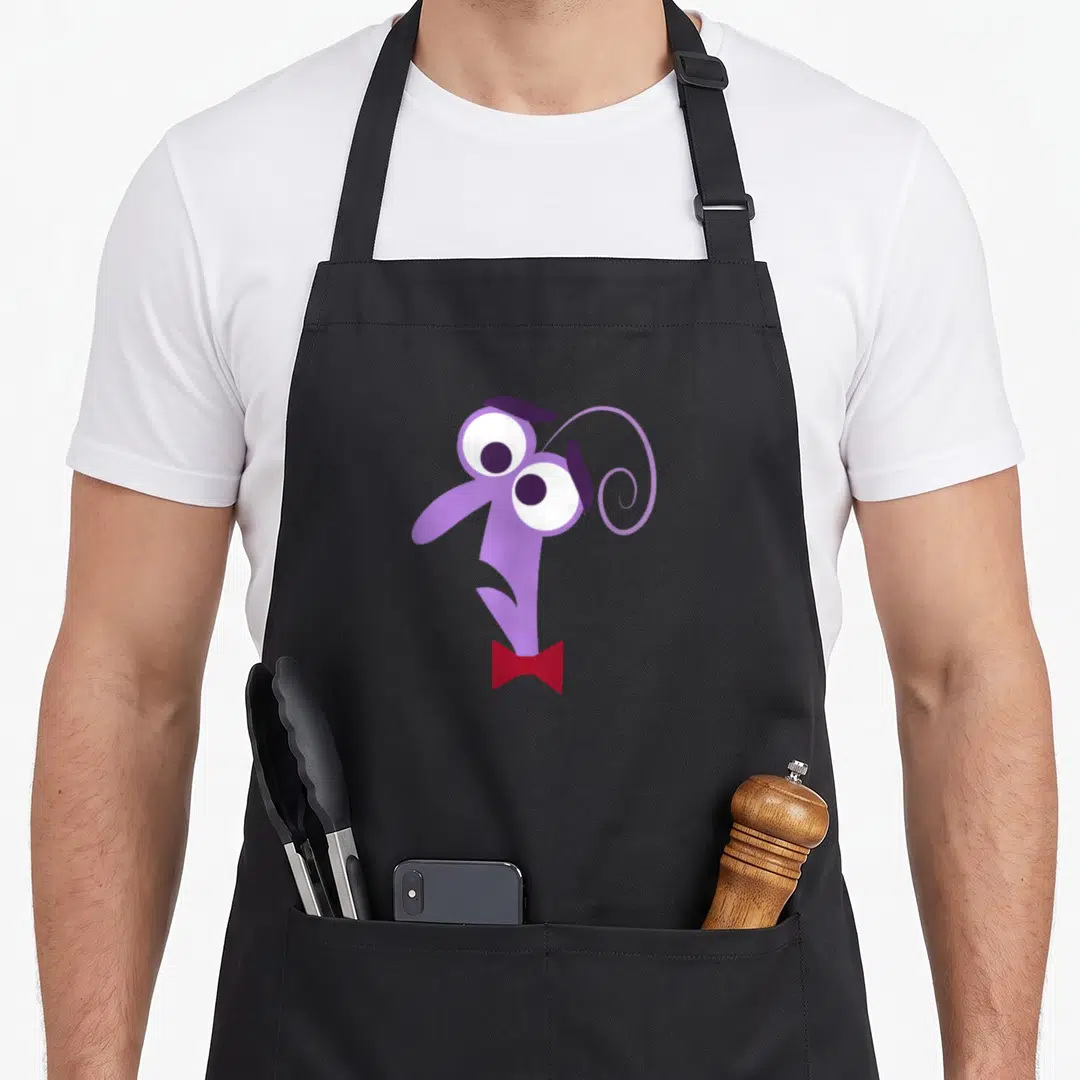 Funny fear apron - Purple cartoon monster head with white eyes and red bow tie — shown on a black cotton canvas apron against a white background