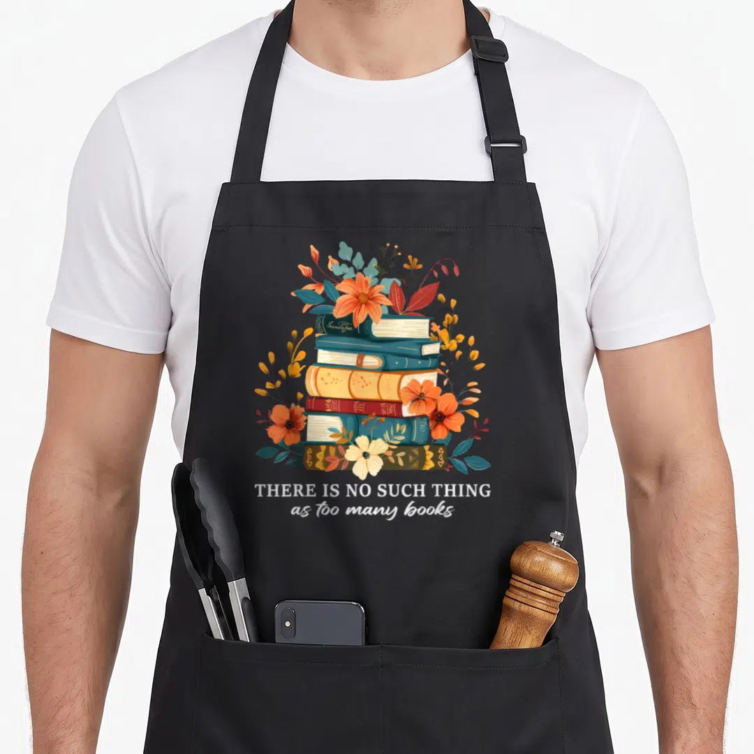 Librarian reading book apron - Stack of books surrounded by orange and blue flowers with white text saying THERE IS NO — shown on a black cotton canvas apron against a white background