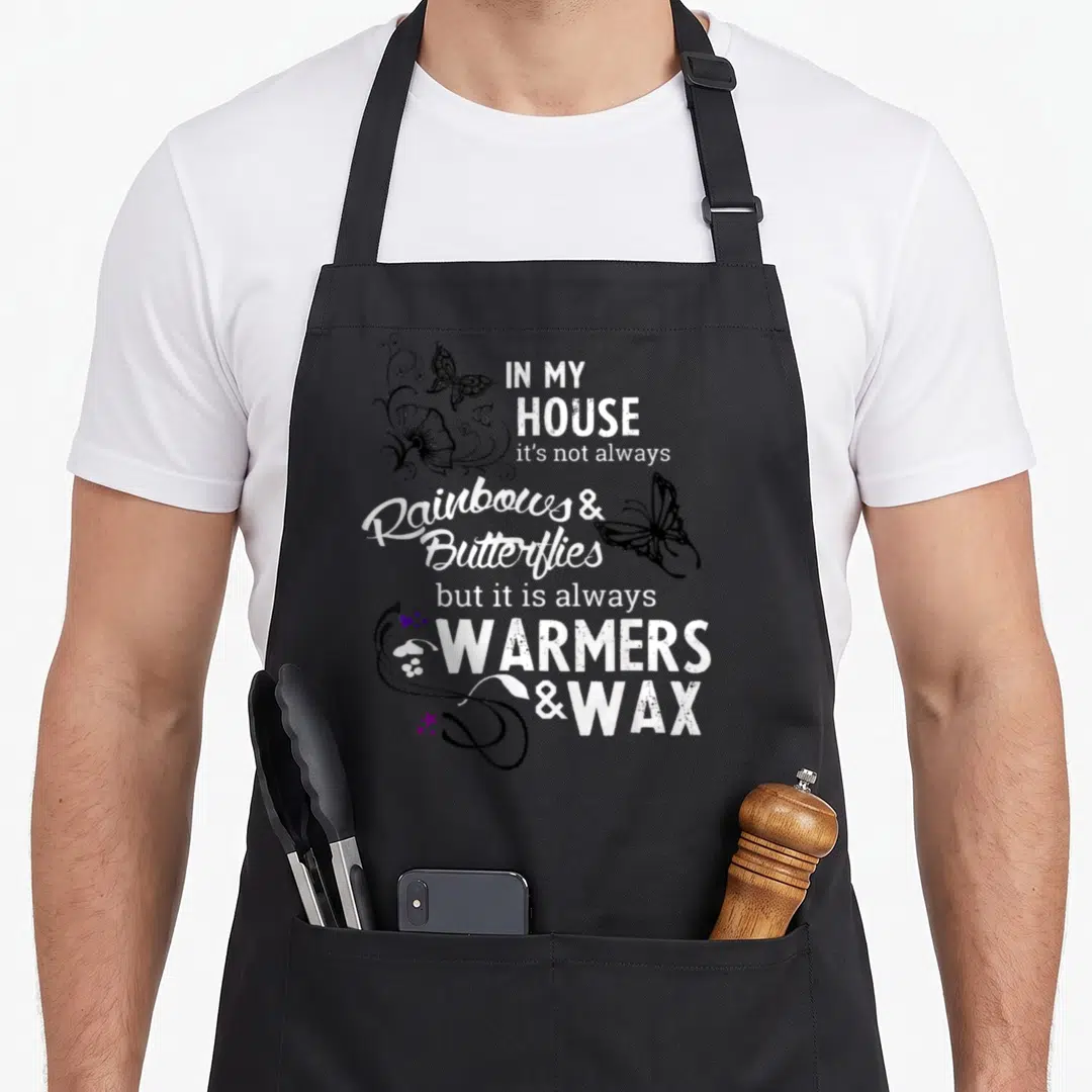 Warmer wax apron - Typography design reading WARMERS & WAX with butterflies and purple hearts — shown on a black cotton canvas apron against a white background