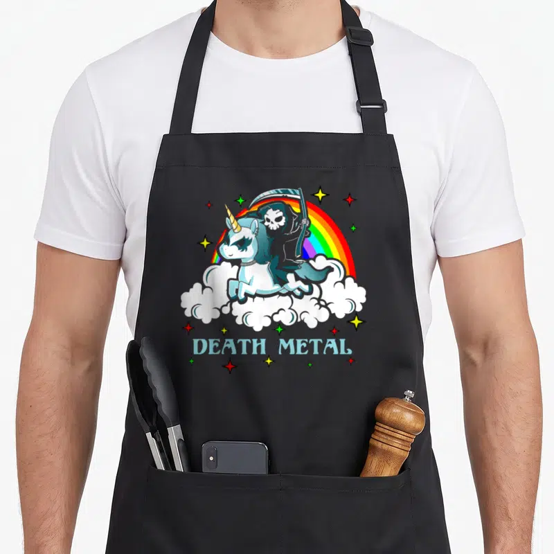 Death unicorn apron - Cartoon Grim Reaper riding blue unicorn over clouds with DEATH METAL text and rainbow — shown on a black cotton canvas apron against a white background