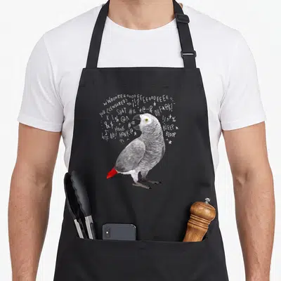 Screaming african aprons - Realistic grey parrot with red tail surrounded by white scream text symbols and WOOOEEEE — shown on a black cotton canvas apron against a white background