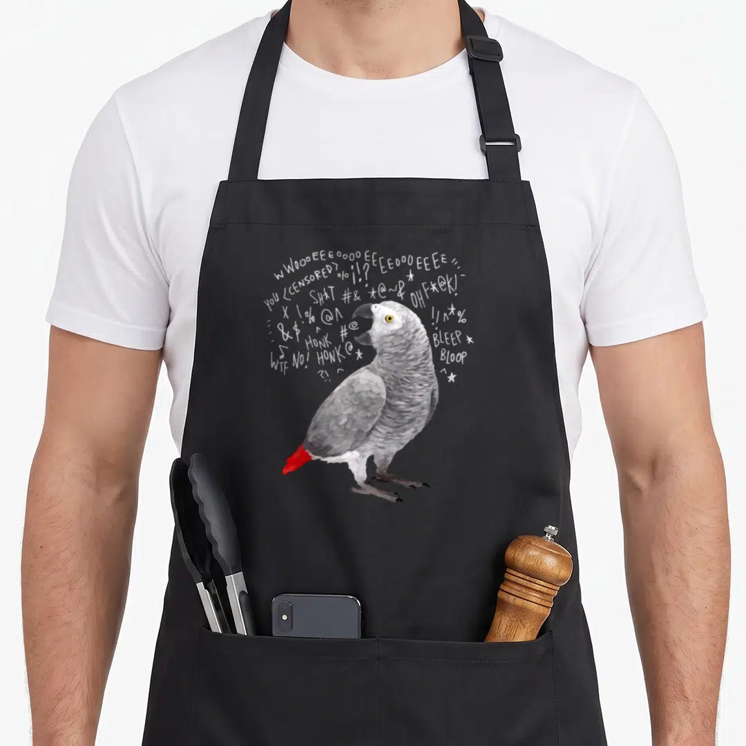 Screaming african aprons - Realistic grey parrot with red tail surrounded by white scream text symbols and WOOOEEEE — shown on a black cotton canvas apron against a white background