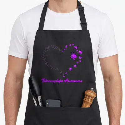 Vintage fibromyalgia awareness apron - Purple heart shape made of stars and butterflies with awareness ribbon and text — shown on a black cotton canvas apron against a white background