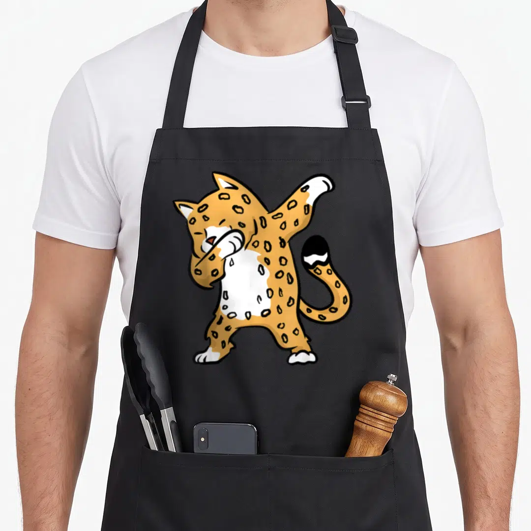 Dab animal apron - Cartoon leopard in dab pose colored orange white and black with spots — shown on a black cotton canvas apron against a white background