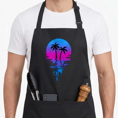 Sunset palm tree apron - Two black palm trees on blue-pink gradient sun with dripping reflection — shown on a black cotton canvas apron against a white background