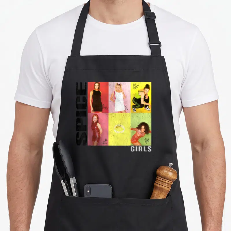 Signiture spice apron - Vertical SPICE text beside grid of five women on red pink yellow and green backgrounds — shown on a black cotton canvas apron against a white background