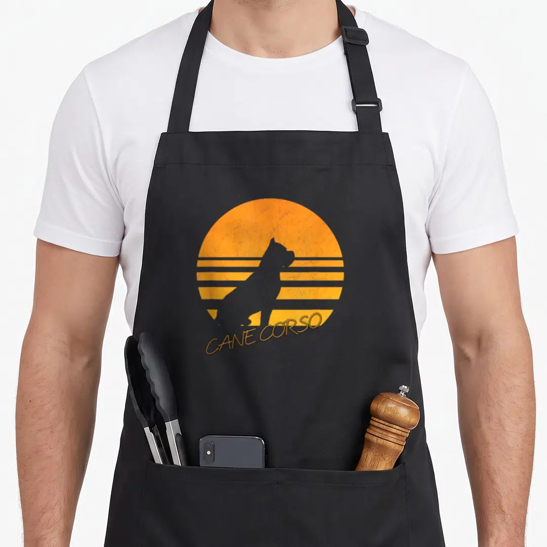 Silhouette cane apron - grey dog silhouette in orange striped circle with curved CANE CORSO text below — shown on a black cotton canvas apron against a white background