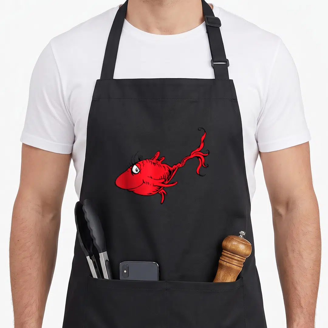 Funny fish apron - Red cartoon fish with long eyelashes and curly tail in black and white — shown on a black cotton canvas apron against a white background