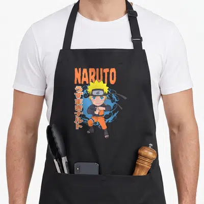Pose anime apron - Chibi Naruto in orange outfit with NARUTO text and vertical Japanese characters against blue smoke — shown on a black cotton canvas apron against a white background
