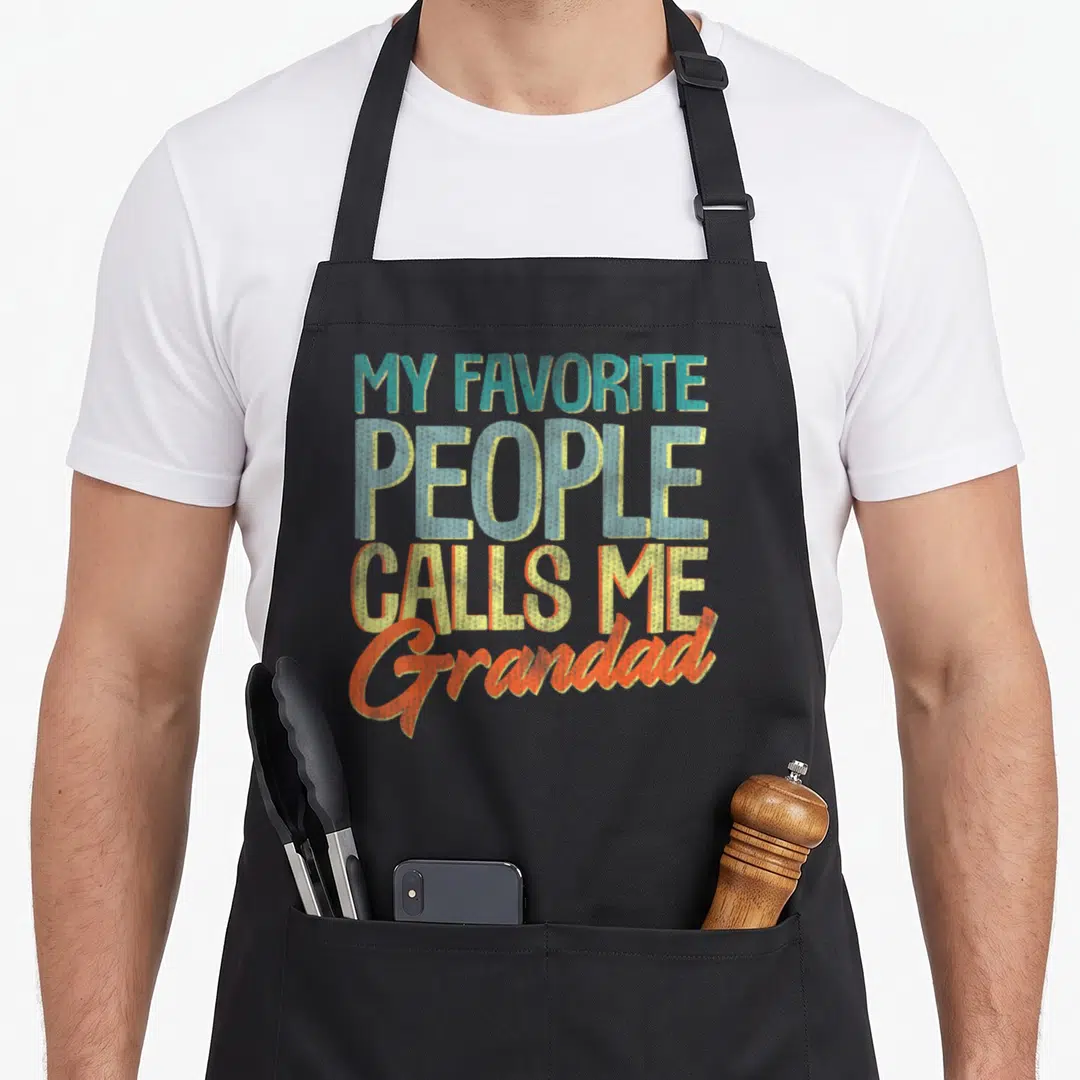 Call father grandad aprons - Stacked text MY FAVORITE PEOPLE CALLS ME Grandad in teal yellow orange fonts — shown on a black cotton canvas apron against a white background
