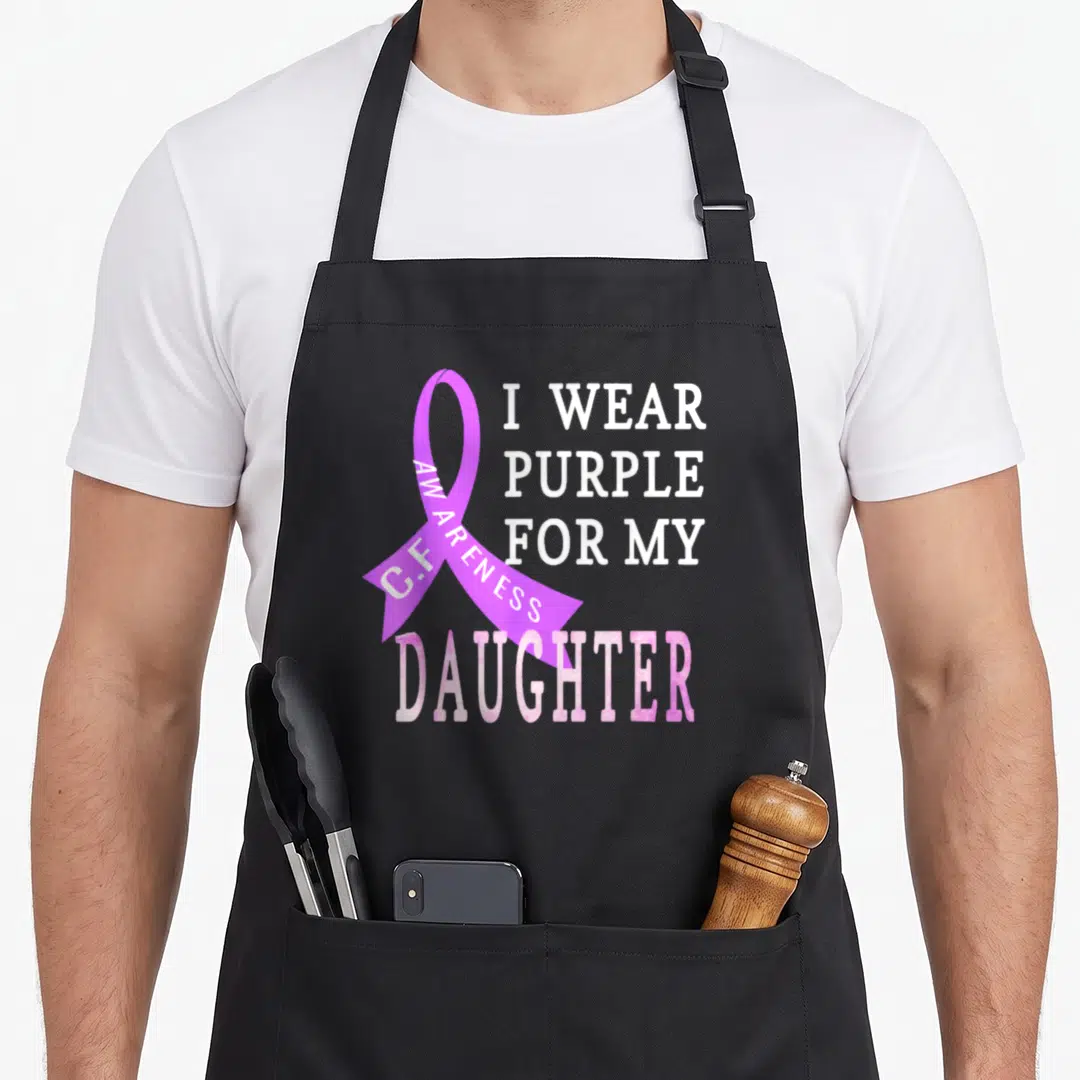 Funny daughter cystic fibrosis awareness apron - Purple ribbon with I WEAR PURPLE FOR MY DAUGHTER text in white and pink — shown on a black cotton canvas apron against a white background