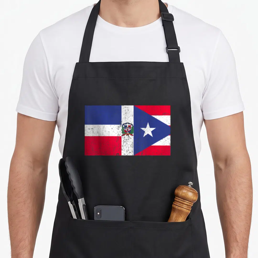 Heritage flag pride apron - Distressed Dominican and Puerto Rican flags joined side-by-side in red blue and white — shown on a black cotton canvas apron against a white background