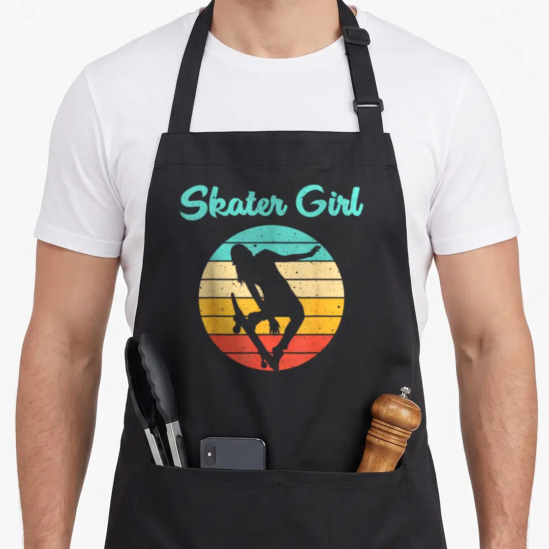 Skater skateboard skateboarding apron - Retro sunset circle with skater girl silhouette and arched Skater Girl text — shown on a black cotton canvas apron against a white background