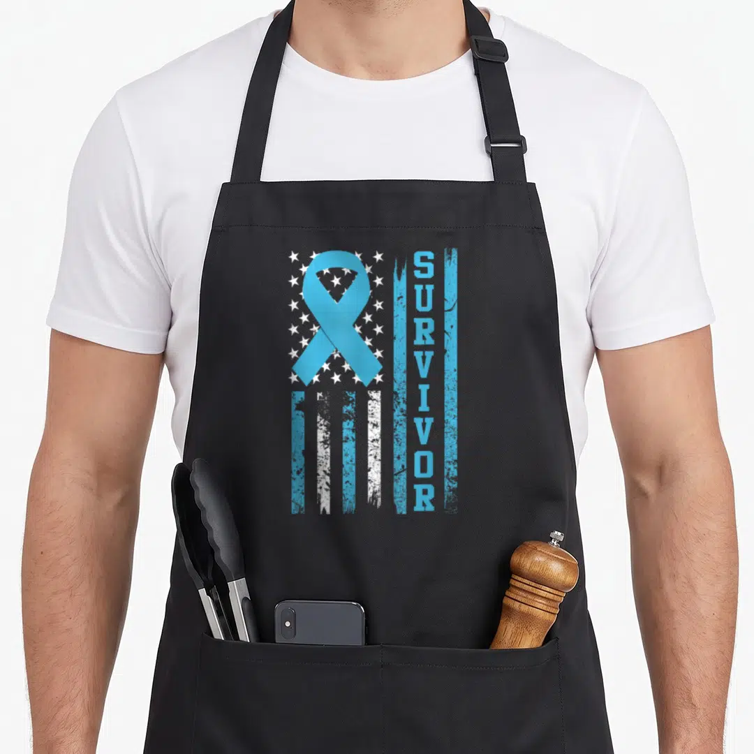 Bold ribbon apron - Light blue ribbon and vertical SURVIVOR text over distressed flag stars and stripes — shown on a black cotton canvas apron against a white background