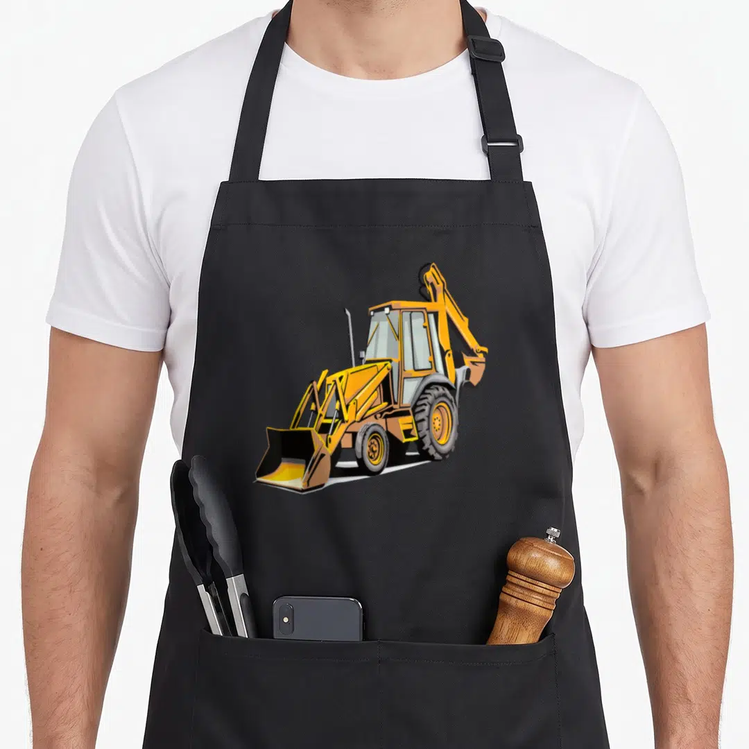 Backhoe construction apron - Yellow cartoon backhoe loader with black bucket and grey tires on plain background — shown on a black cotton canvas apron against a white background