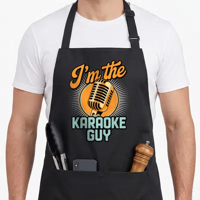 Singing music karaoke apron - Retro microphone graphic with orange circle and blue block letters reading I'm — shown on a black cotton canvas apron against a white background