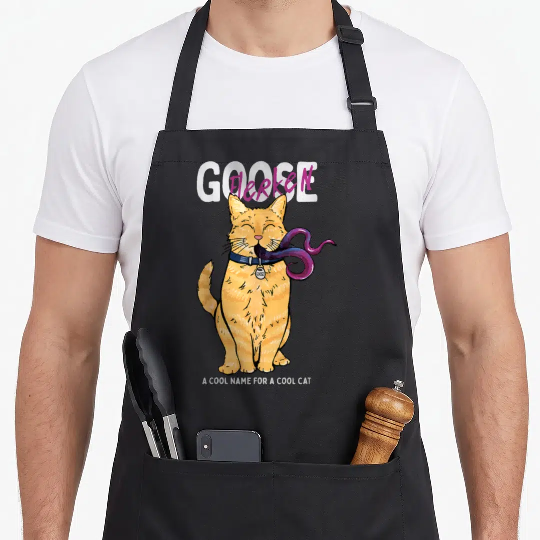 Cat goose apron - Orange cat with purple tentacles and text GOOSE Flerken A COOL NAME FOR A COOL CAT — shown on a black cotton canvas apron against a white background
