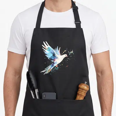 Dove watercolour bird apron - White and blue watercolor dove flying right with multicolored paint splatters — shown on a black cotton canvas apron against a white background