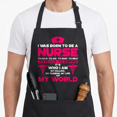 Lvn nurse apron - Pink and white nurse cap and caduceus symbols surrounding stacked text about nursing calling — shown on a black cotton canvas apron against a white background
