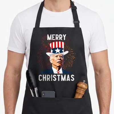 Joe fourth of july aprons - Photo of Joe Biden in patriotic hat with Merry Christmas text and red blue fireworks — shown on a black cotton canvas apron against a white background