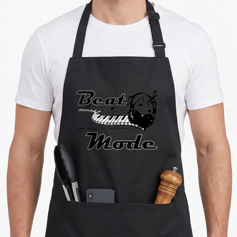 Beat producer lover apron - Black and white curved keyboard with headphones and Beat Mode text — shown on a black cotton canvas apron against a white background