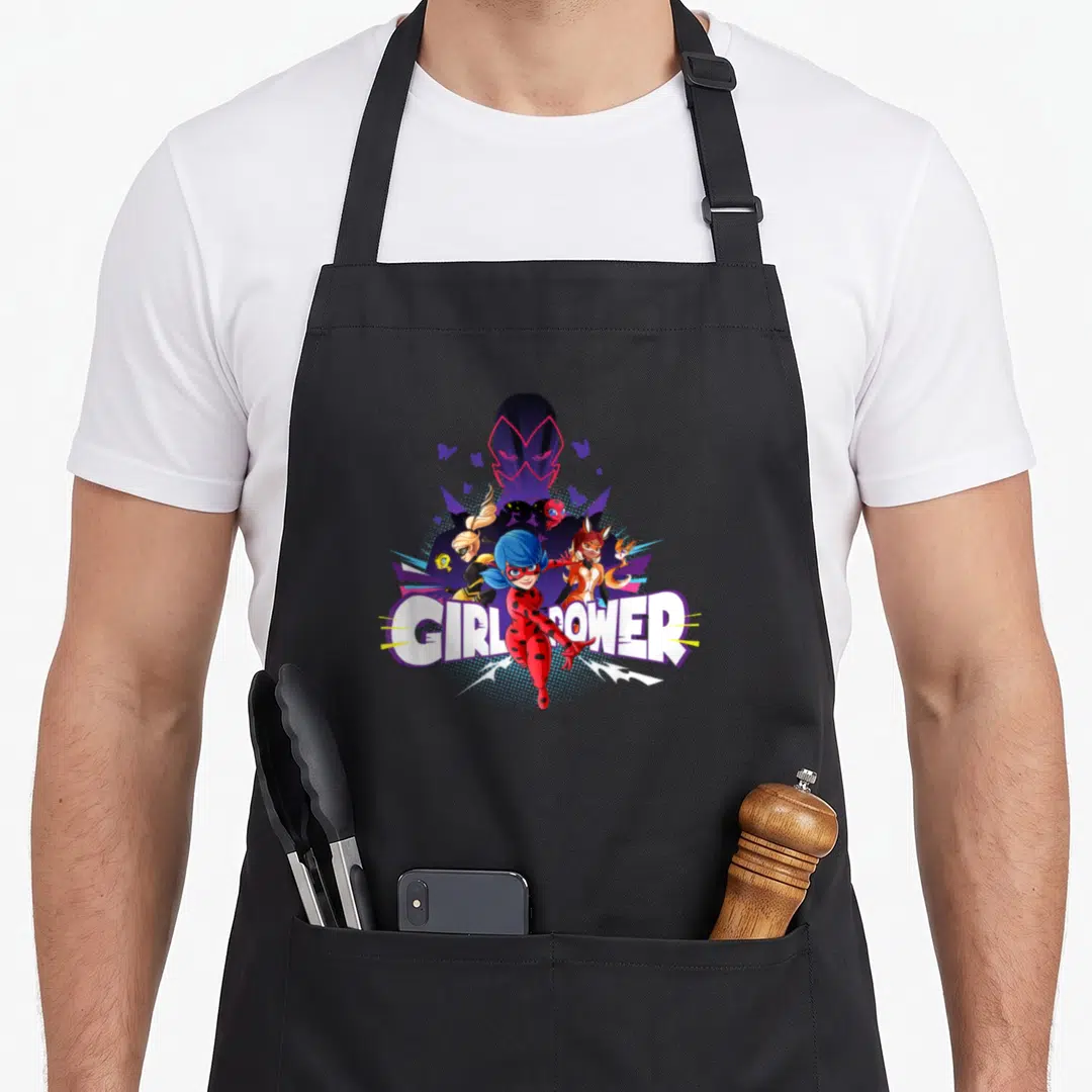 Moth ladybug apron - GIRL POWER text below female superheroes and purple mask in red blue purple cartoon art — shown on a black cotton canvas apron against a white background