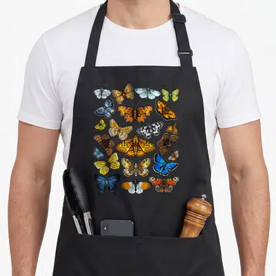 Funny collection butterfly apron - Realistic grid of orange, blue, yellow, and brown butterflies and moths on canvas — shown on a black cotton canvas apron against a white background