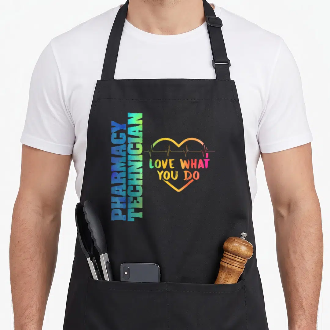Student pharmacist apron - PHARMACY TECHNICIAN stacked text next to heart with heartbeat line and LOVE WHAT YOU DO — shown on a black cotton canvas apron against a white background