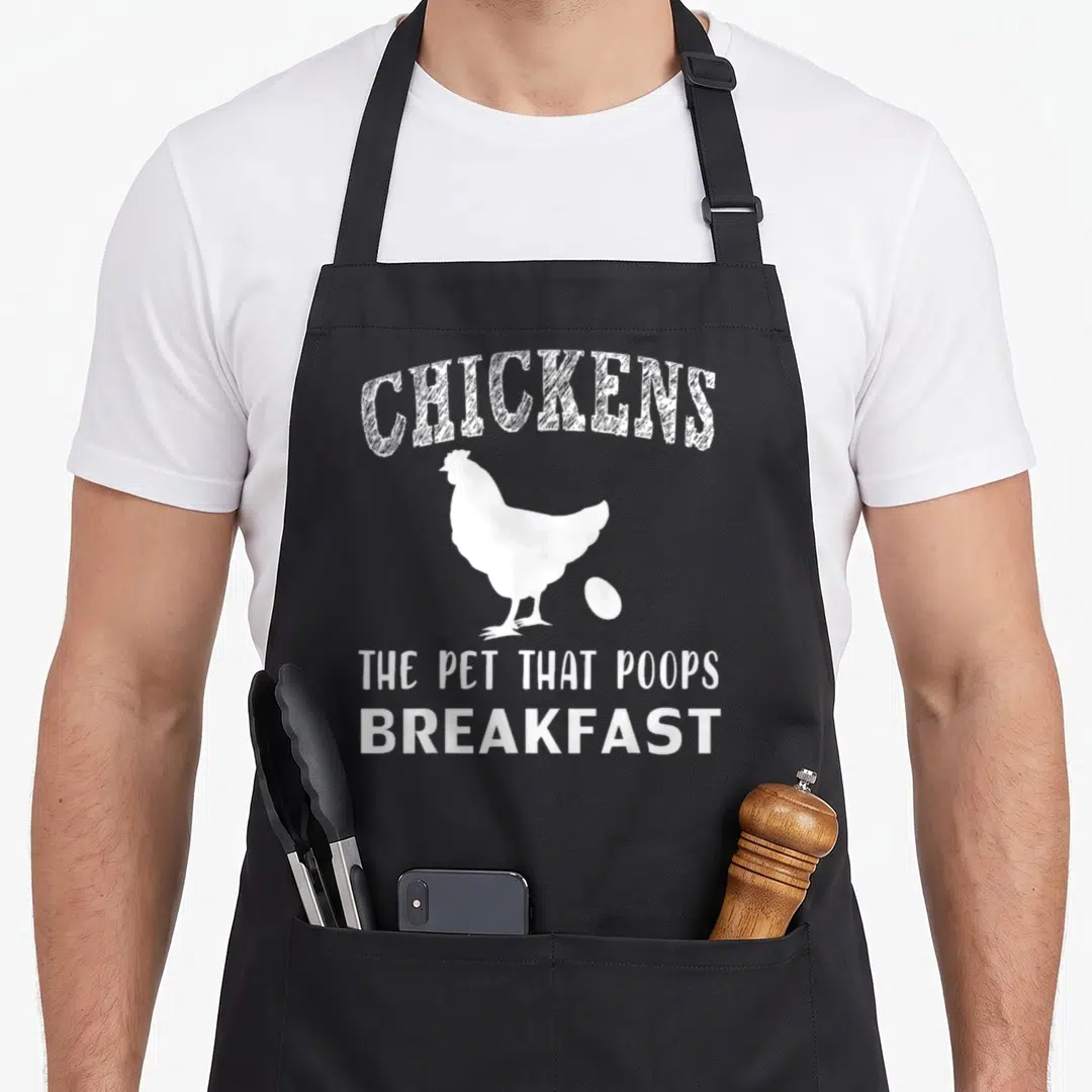 Pet chicken apron - White arched text CHICKENS above chicken silhouette and egg with stacked text below — shown on a black cotton canvas apron against a white background