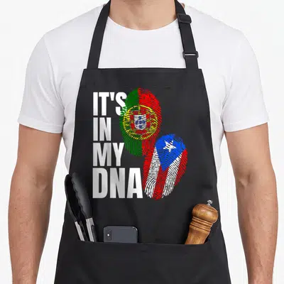 Mix portuguese apron - Stacked text IT'S IN MY DNA beside fingerprint shaped Portuguese and Puerto Rican flags — shown on a black cotton canvas apron against a white background