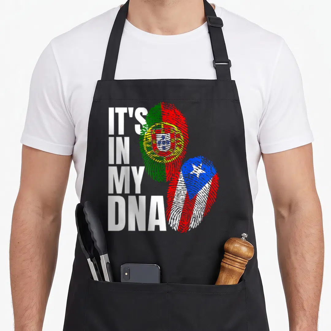 Mix portuguese apron - Stacked text IT'S IN MY DNA beside fingerprint shaped Portuguese and Puerto Rican flags — shown on a black cotton canvas apron against a white background