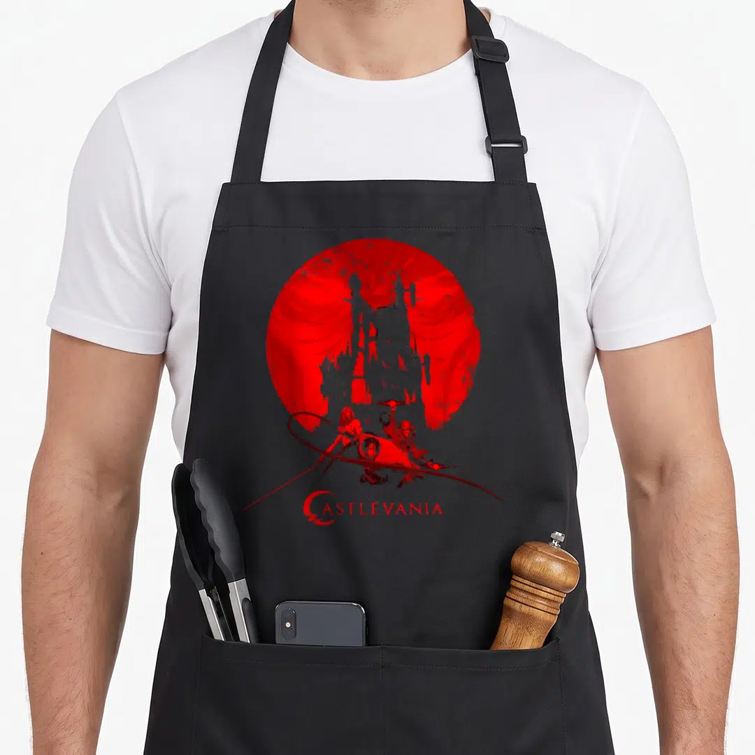 Castlevania metroidvania apron - Red moon, grey castle silhouette, three figures, distressed CASTLEVANIA text — shown on a black cotton canvas apron against a white background