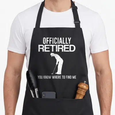 Officially golf apron - White distressed golfer silhouette with officially retired text — shown on a black cotton canvas apron against a white background
