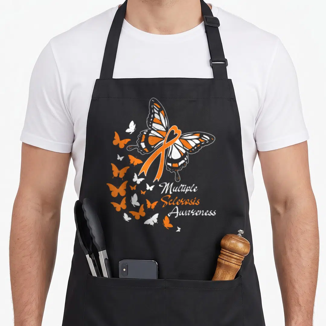 Multiple butterfly apron - Orange ribbon heart over butterfly with scattered wings and stacked awareness text — shown on a black cotton canvas apron against a white background