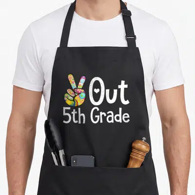 5th grade girls apron - Colorful peace sign hand next to white Out 5th Grade text with speckled font — shown on a black cotton canvas apron against a white background