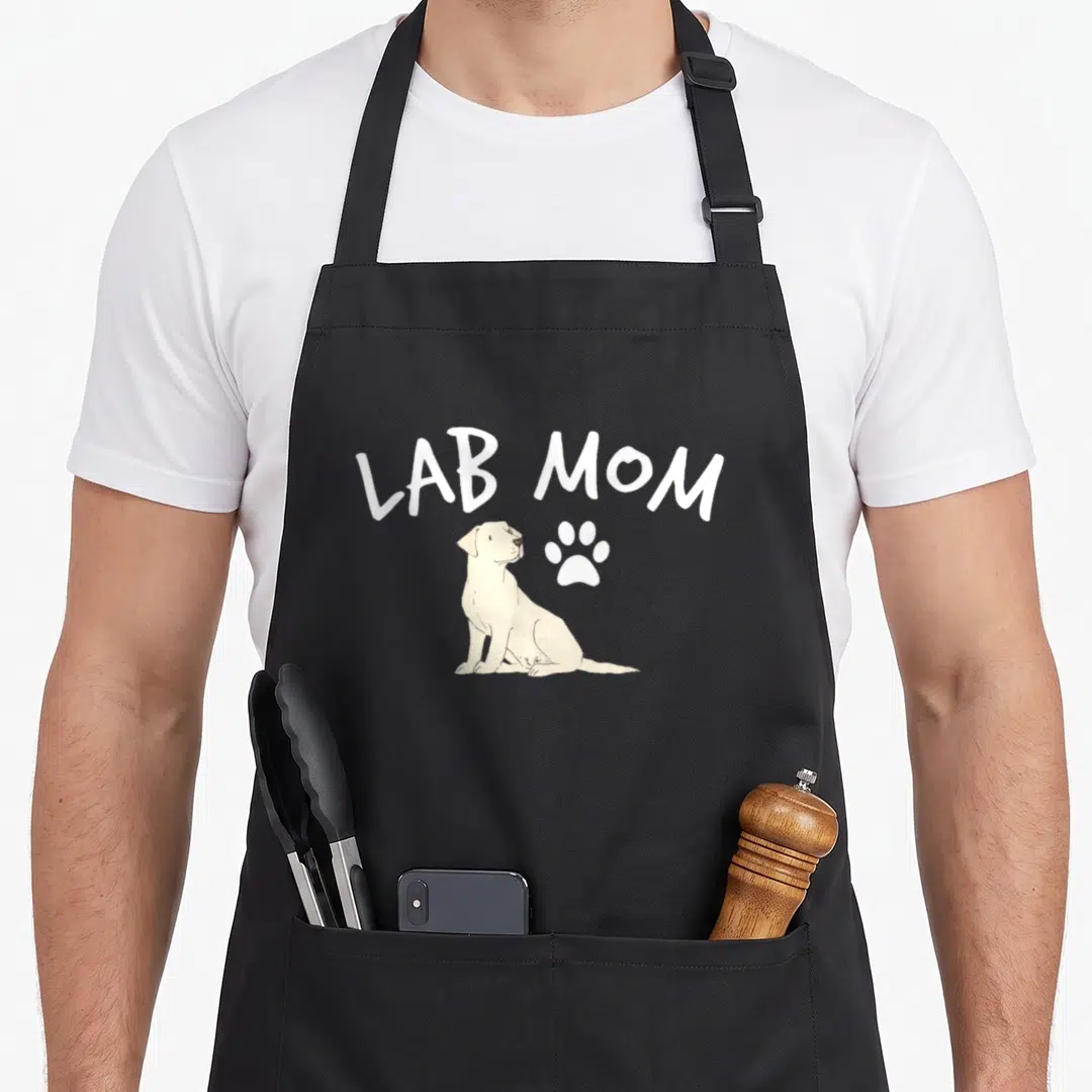 Puppy labrador apron - LAB MOM text above cream sitting dog and white paw print — shown on a black cotton canvas apron against a white background