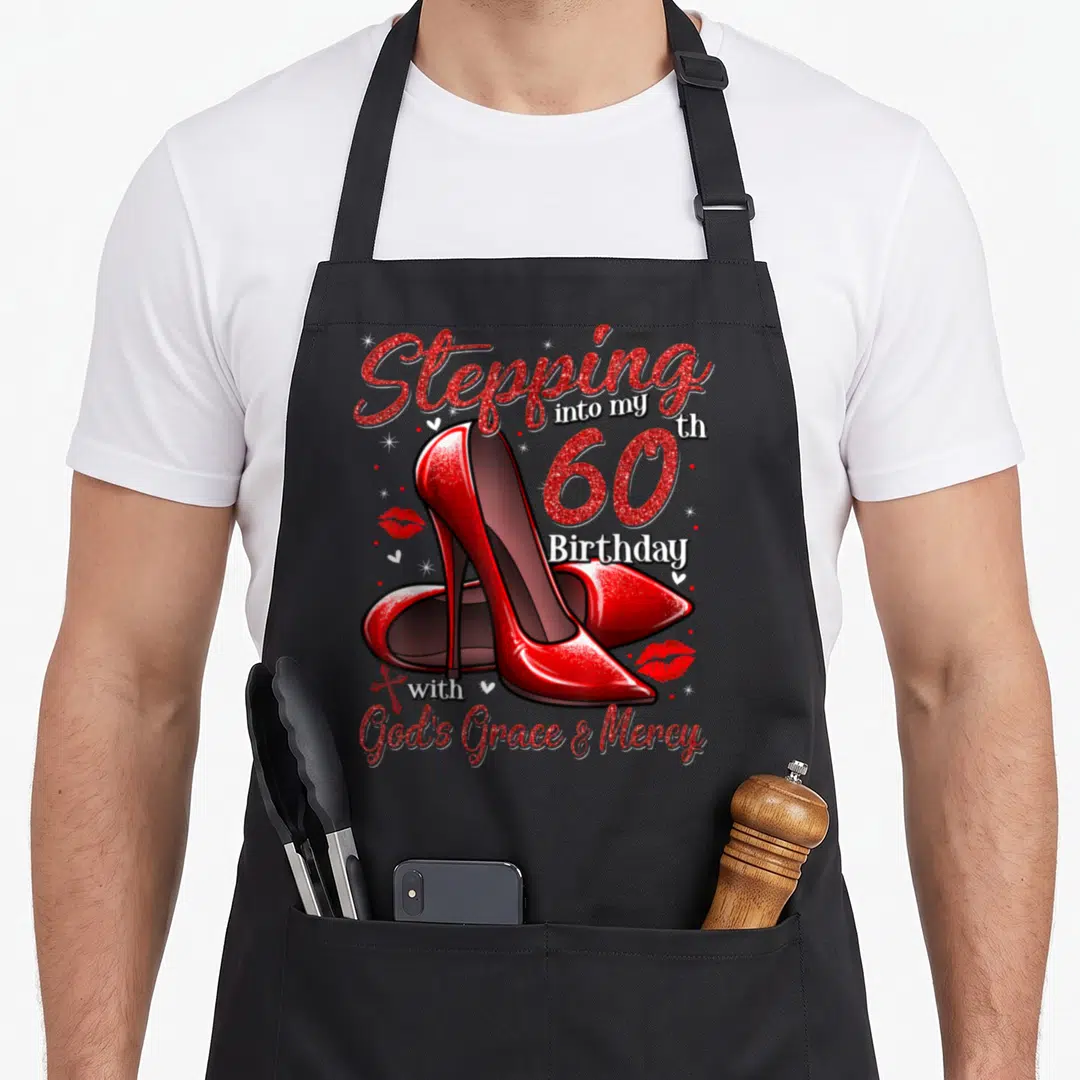 Heel stepping 60th birthday apron - Red high heels and Stepping into my th 60 Birthday with God's Grace & Mercy text — shown on a black cotton canvas apron against a white background