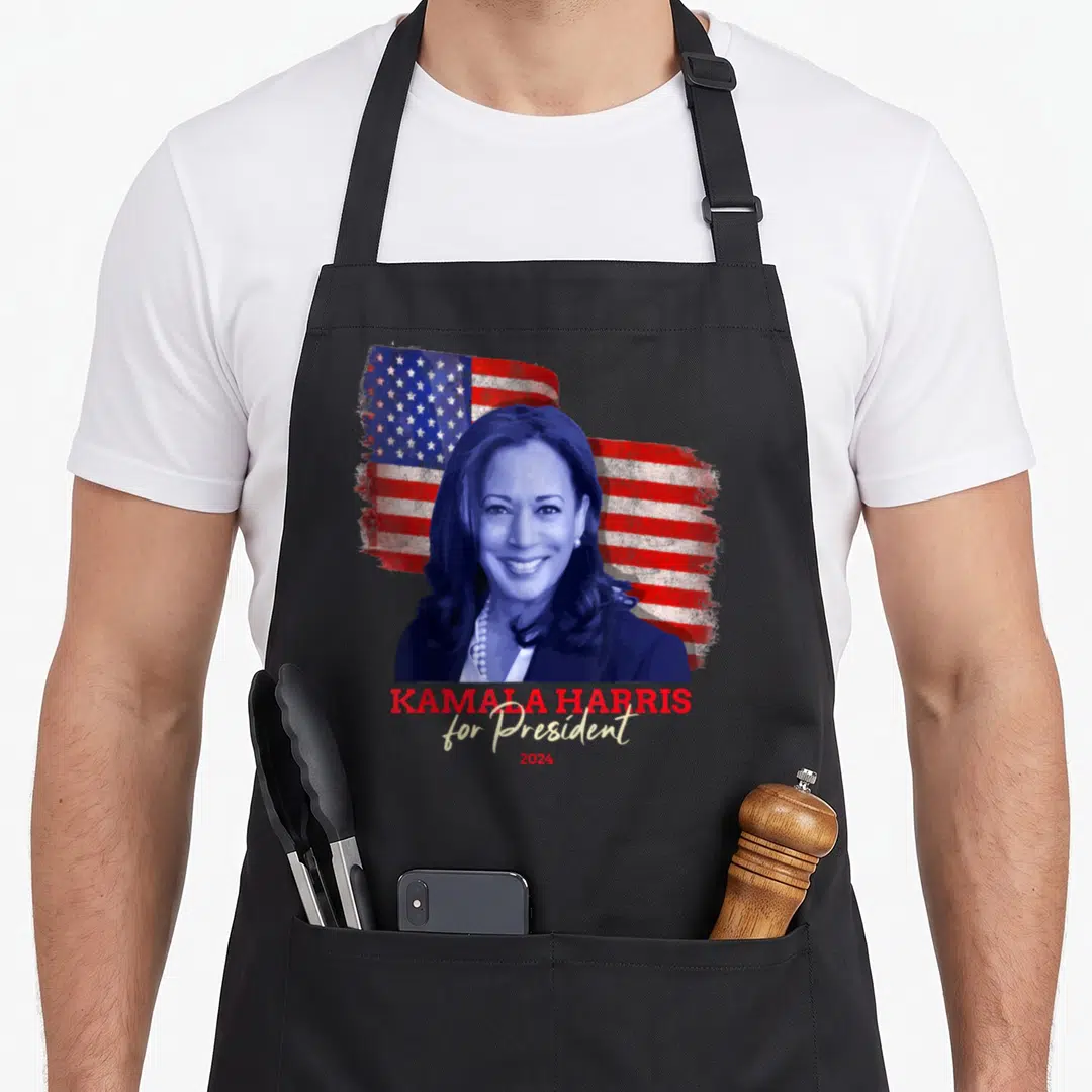 Harris presidents apron - Kamala Harris portrait over distressed flag with KAMALA HARRIS for President 2024 text — shown on a black cotton canvas apron against a white background