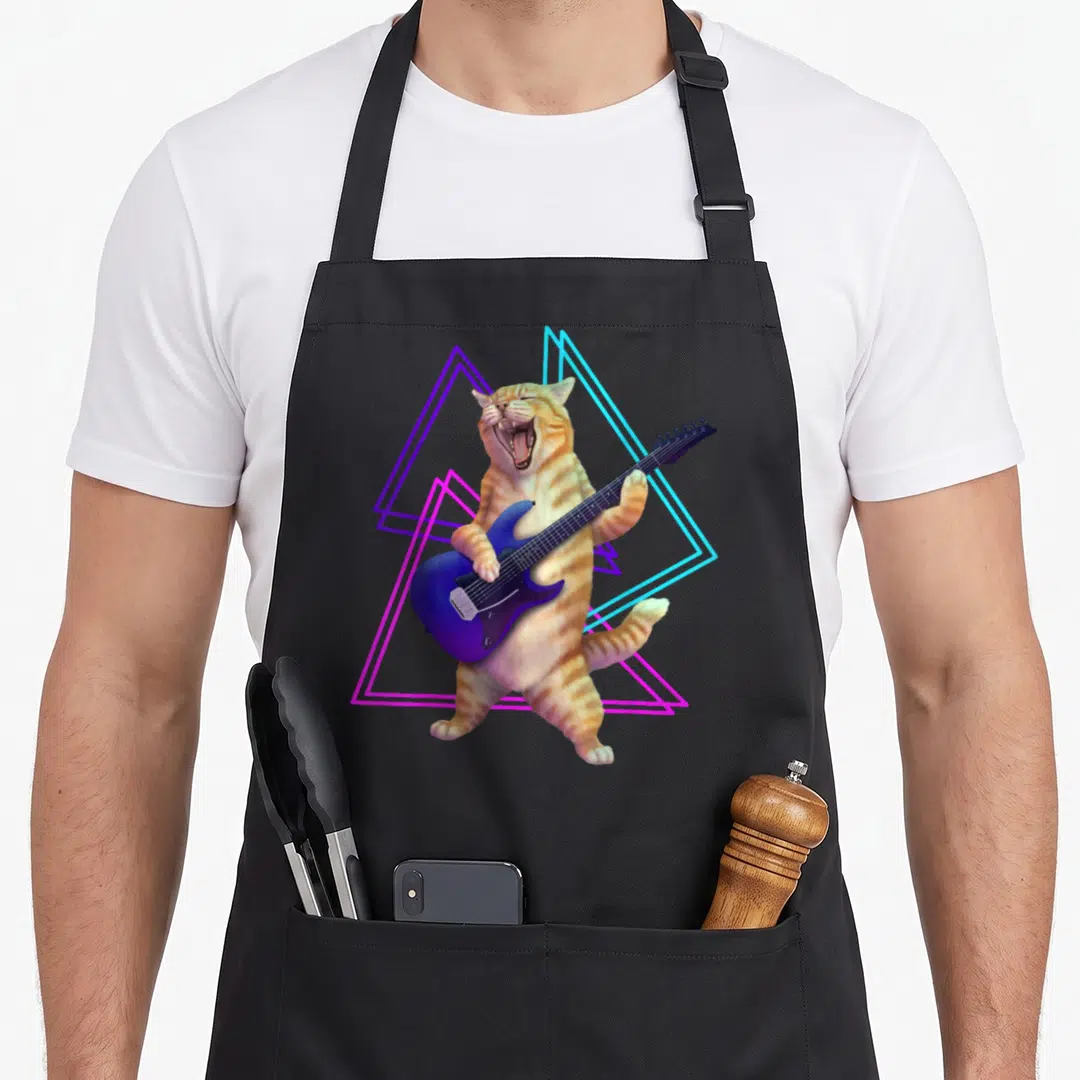 Guitar kitty cat apron - Orange tabby playing blue electric guitar with neon purple blue and pink triangles — shown on a black cotton canvas apron against a white background