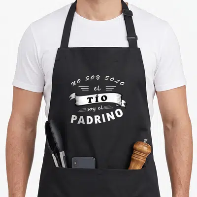Playera paratrooper apron - Spanish text no soy solo el tio soy el padrino on black apron — shown on a black cotton canvas apron against a white background